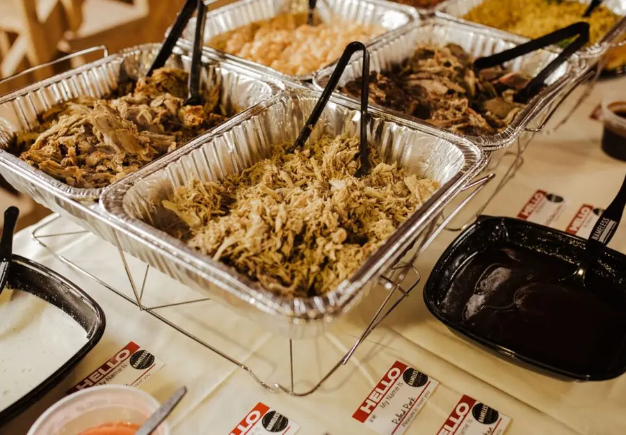 Trays of slow smoked brisket and pulled pork on a wedding buffet