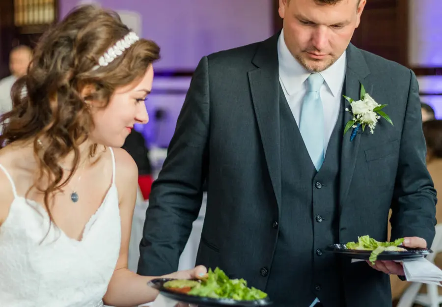 A couple filling their plates at the wedding buffet