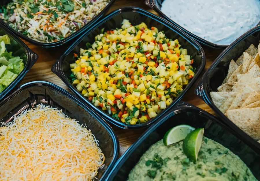A build your own taco bar with corn salsa, cheese and guacamole