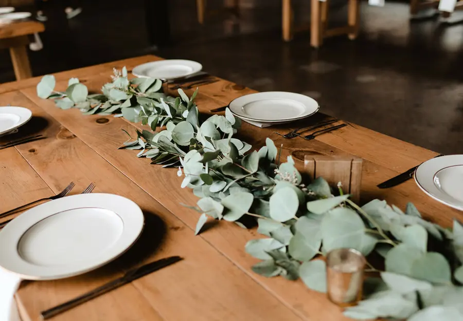 A long table dressed with eucalyptus and white china